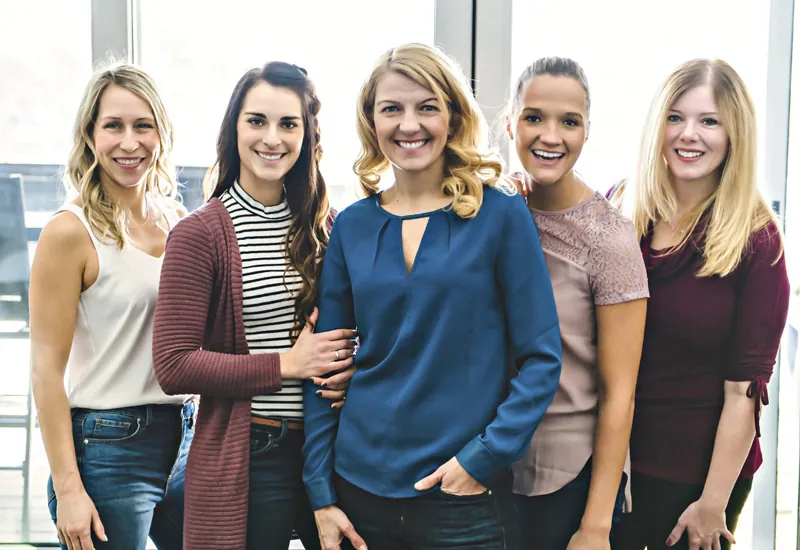 Fünf Frauen aus dem PayRocknRoll-Team stehen lachend nebeneinander